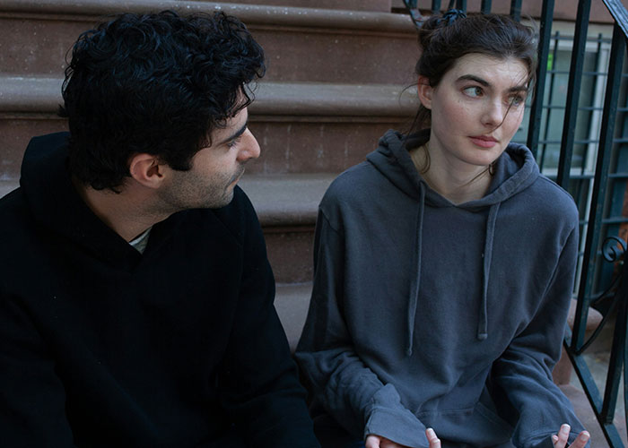 Couple sitting on outdoor steps, woman looking upset while man talks, reflecting a relationship conflict online. Couple sitting on outdoor steps, woman looking upset while man talks, reflecting a relationship conflict online.