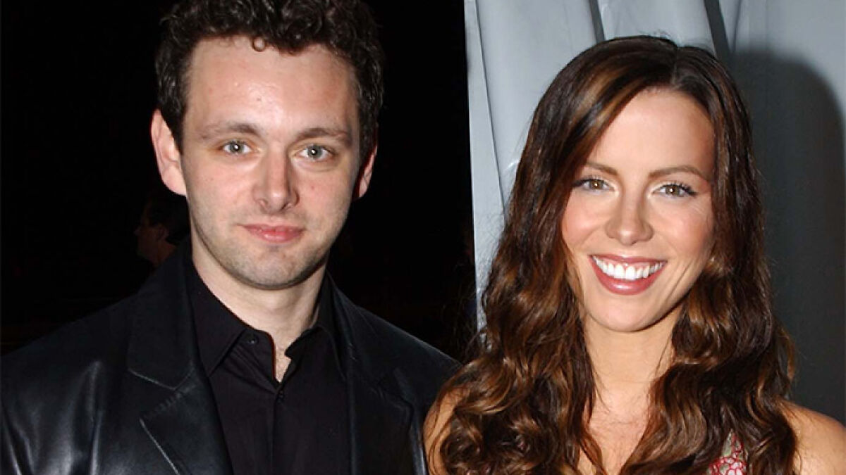 Michael Sheen and a woman smiling together at an event, highlighting Michael Sheen dating history.