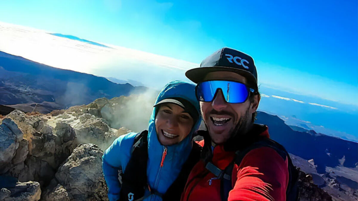 Couple hiking on mountain peak with clear blue sky, related to boyfriend who abandoned woman on Austrian mountain.