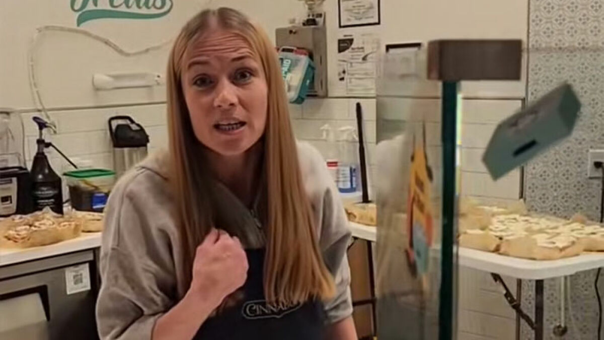 Cinnabon worker in a bakery setting expressing emotion during a confrontation involving a Somali couple and accusations of racism.