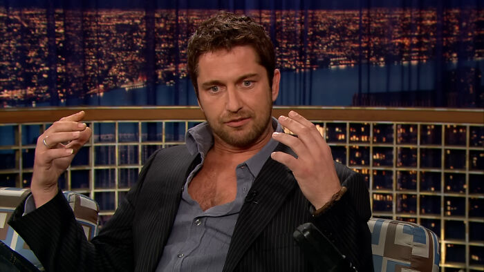 Actor in a dark suit sharing a story during a late-night talk show about encounters with celebrities.