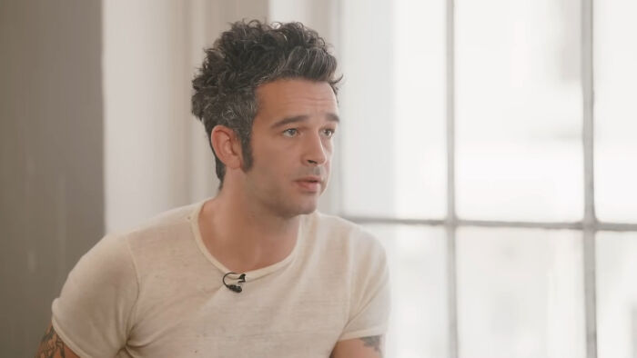 Man with spiked hair and white shirt speaking in casual interview setting about celebrity encounters with mere mortals.