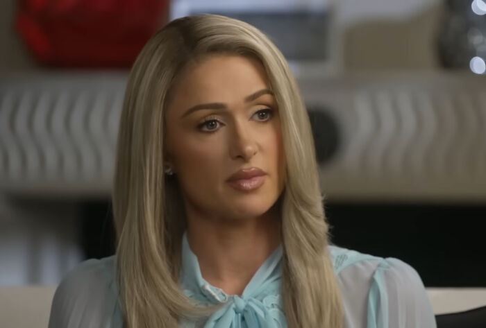 Woman with long blonde hair and light blue blouse sharing a story about running into celebrities in an interview setting