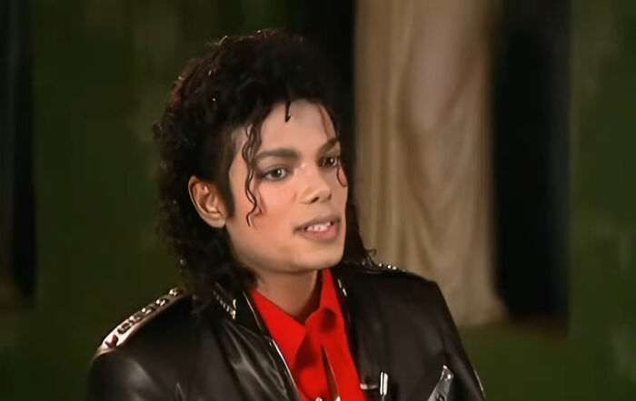 Michael Jackson in a black leather jacket and red shirt, a memorable celebrity encounter captured on camera.