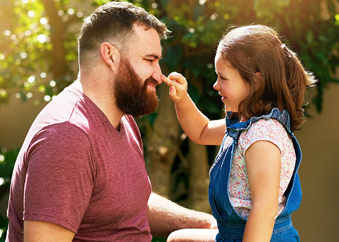 Father and daughter sharing a playful moment outdoors, illustrating the innocence behind creepy things kids said that startled parents.