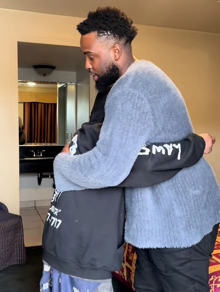 Two men hugging in a motel room, highlighting a co-star's update about struggling Nickelodeon star's motel stay.