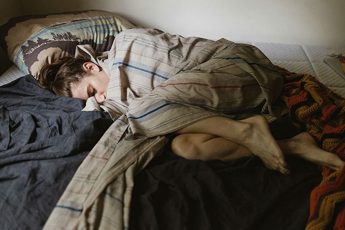 Woman wrapped in blanket lying on bed, reflecting exhaustion and frustration during Thanksgiving with brother-in-law tensions. Woman wrapped in blanket lying on bed, reflecting exhaustion and frustration during Thanksgiving with brother-in-law tensions.