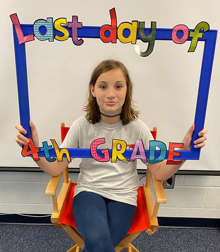 Young girl holding a colorful last day of 4th grade frame, highlighting accused teens luring tactic in disturbing woods incident Young girl holding a colorful last day of 4th grade frame, highlighting accused teens luring tactic in disturbing woods incident