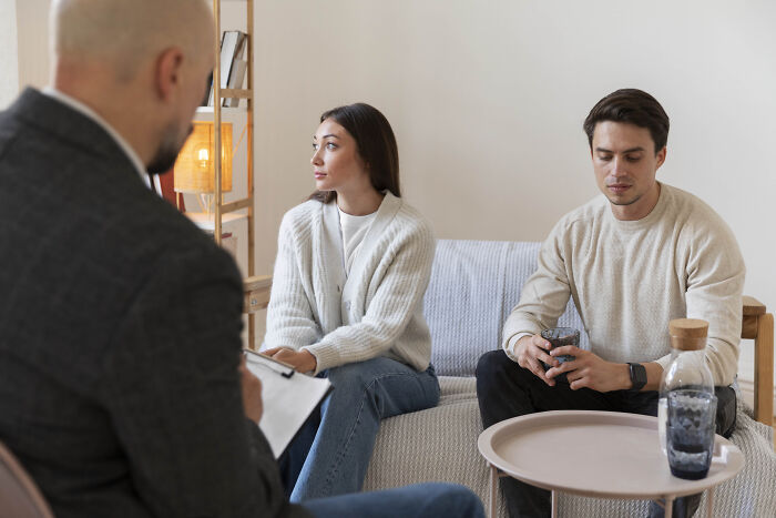 Couple discussing relationship challenges with a therapist, highlighting experiences of dating outside of their culture.