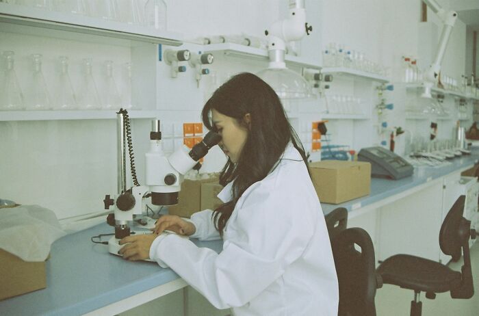 Woman in lab coat using a microscope in a laboratory, symbolizing people online sharing crazy facts they know. Woman in lab coat using a microscope in a laboratory, symbolizing people online sharing crazy facts they know.