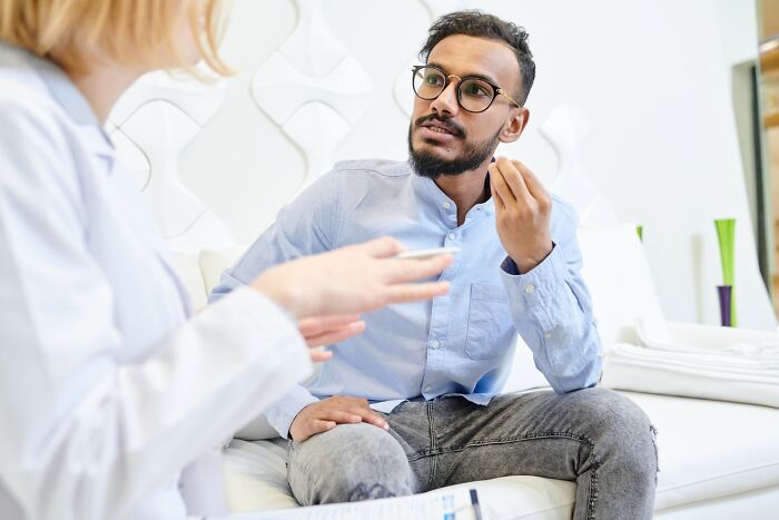 Man without degree discussing ideas with woman in a modern office, illustrating incredible minds and genius potential.