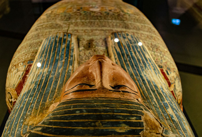 Ancient Egyptian sarcophagus with detailed face and painted patterns, a disturbing find in homes of seemingly normal people.