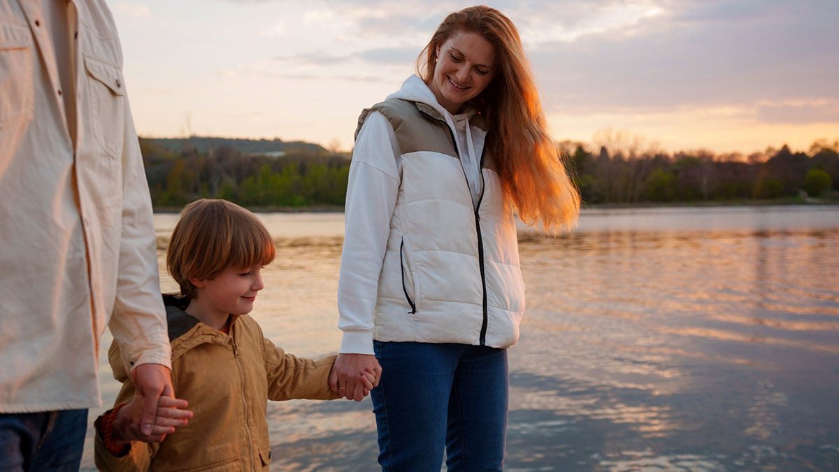 Family walking by the lake at sunset, highlighting themes of marriage and tracking wife's phone locations at night.