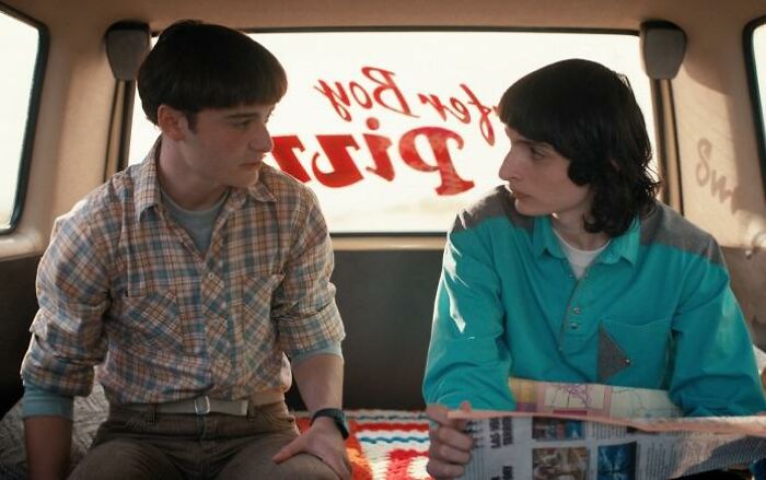 Two Stranger Things 5 characters sit inside a van, having a serious conversation, highlighting the show's comically bad moments. Two Stranger Things 5 characters sit inside a van, having a serious conversation, highlighting the show's comically bad moments.