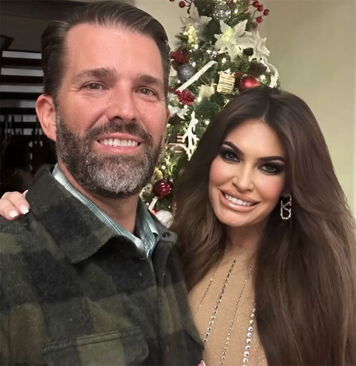 Donald Trump Jr. and fianc&eacute;e smiling together in front of a decorated Christmas tree after recent breakup and engagement news.