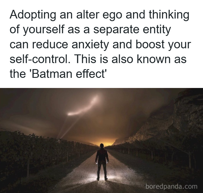 Person standing on a dark road with bat signal lights in the sky illustrating a psychology fact about anxiety and self-control.