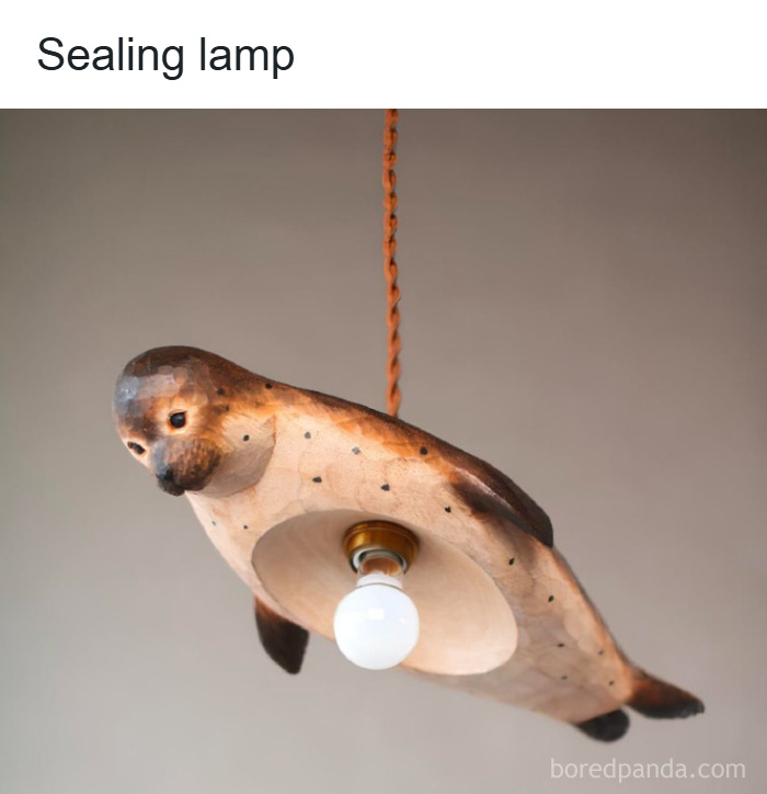 Wooden seal-shaped hanging lamp with light bulb, showcasing quirky design for funny unhinged memes grapejuiceboys decor.
