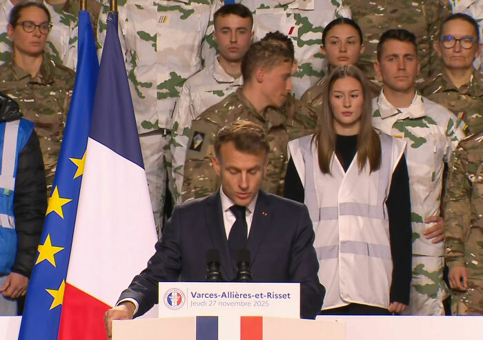 French soldier stands behind Macron exhibiting odd behavior before abruptly leaving the stage amid France boiling tensions