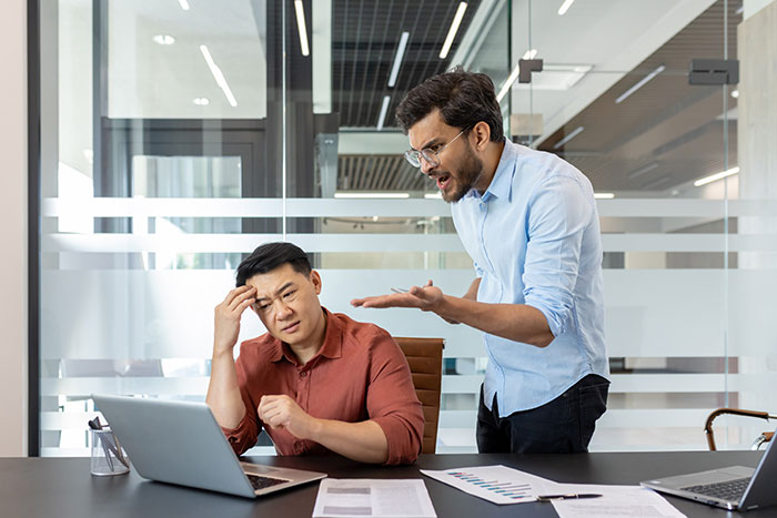 Boss aggressively confronting employee in office, illustrating a tense workplace where threats of termination lead to unexpected consequences.