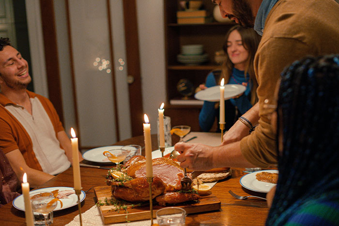 Woman preparing Christmas dinner while others sit, highlighting men feeling entitled to do nothing during Christmas. Woman preparing Christmas dinner while others sit, highlighting men feeling entitled to do nothing during Christmas.