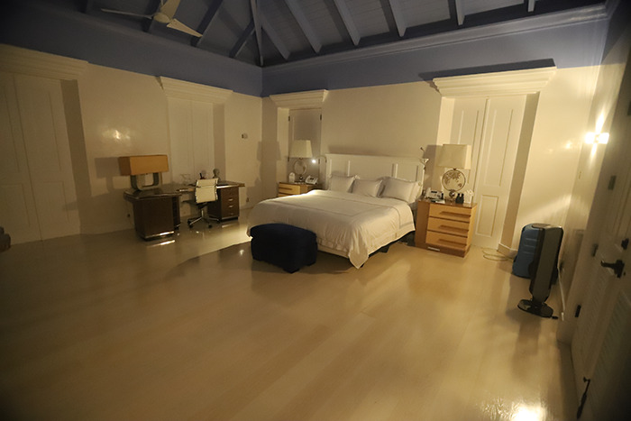 Spacious bedroom inside Epstein’s private island home with a large bed, desk, and soft, dim lighting at night. Spacious bedroom inside Epstein’s private island home with a large bed, desk, and soft, dim lighting at night.
