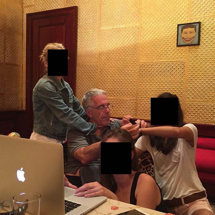 Man and three women with faces obscured sitting by a laptop, related to new Epstein files revealing photos of women.