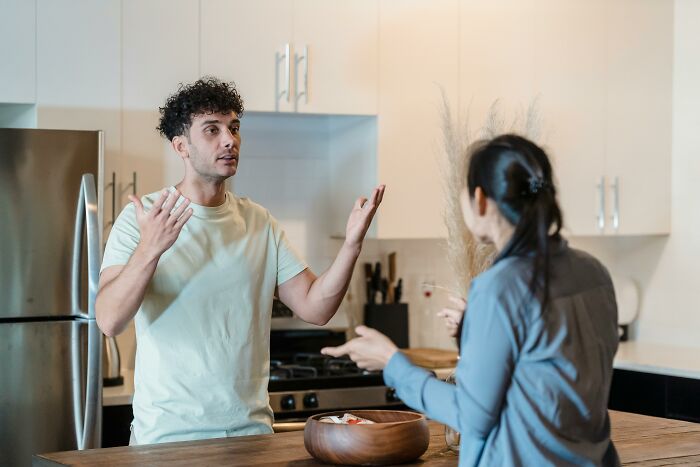Two people having a serious conversation in a kitchen setting, reflecting on moral compass dilemmas and choices.