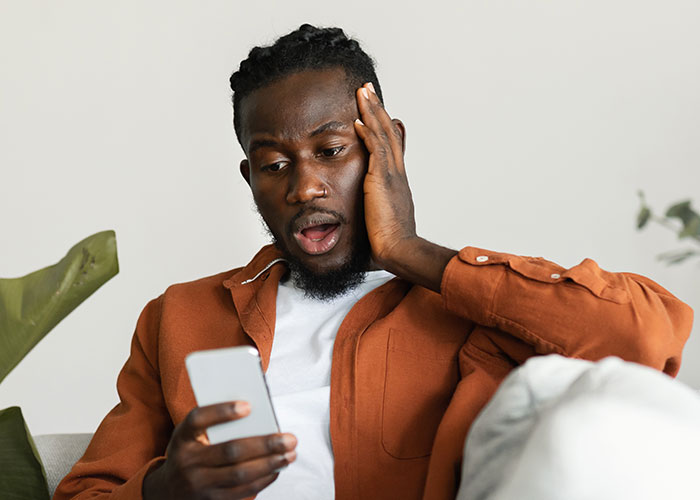 Man surprised and shocked looking at phone, reacting to unexpected message after fiancé disappeared years ago. Man surprised and shocked looking at phone, reacting to unexpected message after fiancé disappeared years ago.