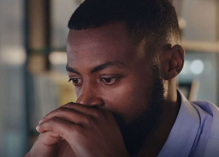 Man with a beard looking thoughtful and sad, reflecting on being left without closure after fianc&eacute; disappears before wedding.