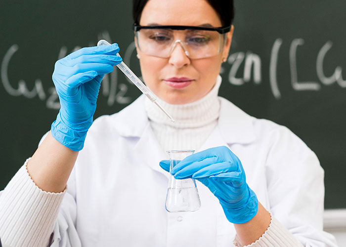 Scientist in lab coat and gloves handling chemicals, illustrating a concept related to former cult members' experiences.