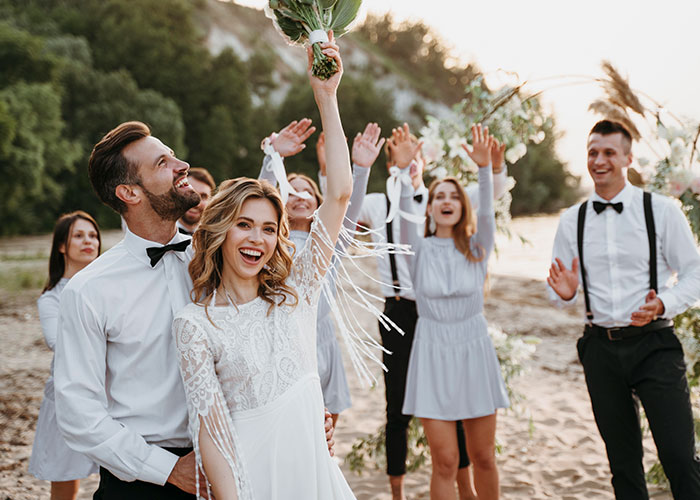 Bride in white dress holding bouquet with groom and friends celebrating outdoors, capturing the moment former cult members realized it was a real cult