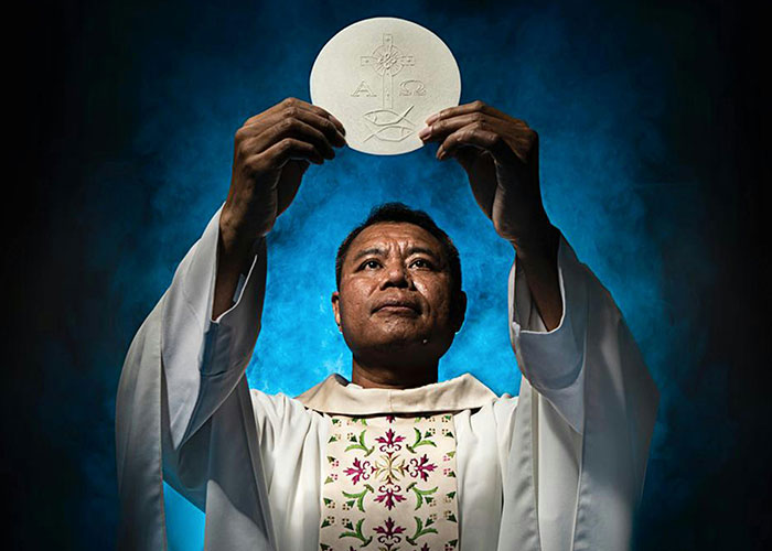 Man in religious robes holding a communion wafer, symbolizing realization of being in a cult moment.