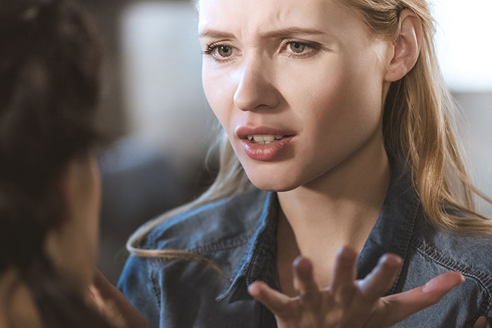 Young woman looking upset and regretful after blowing up at family during Thanksgiving dinner conversation.