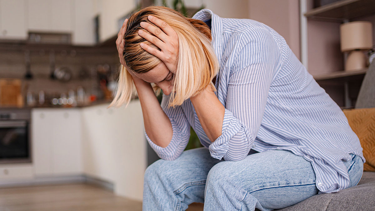 Woman feeling regret and upset at home after blowing up at family during Thanksgiving dinner conflict.
