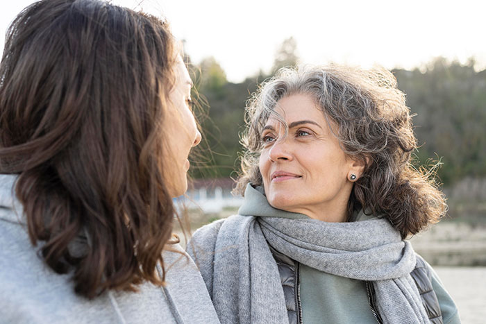 Mom and daughter having a serious conversation outdoors, reflecting tension from Disney trip family exclusion conflict. Mom and daughter having a serious conversation outdoors, reflecting tension from Disney trip family exclusion conflict.