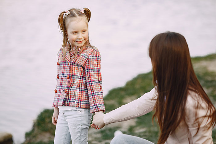 Mom and daughter holding hands outdoors, reflecting emotions related to Disney trip exclusion and family conflict. Mom and daughter holding hands outdoors, reflecting emotions related to Disney trip exclusion and family conflict.