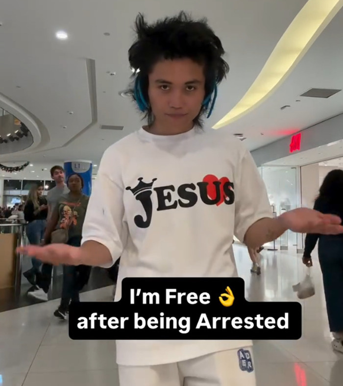 Man wearing headphones and a Jesus shirt in a mall after arrest linked to Ariana Grande attack and Lady Gaga concert trouble.