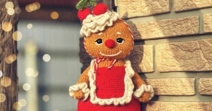 Knitted gingerbread man toy wearing a red apron, designed by a toy designer, capturing hearts this Christmas season.