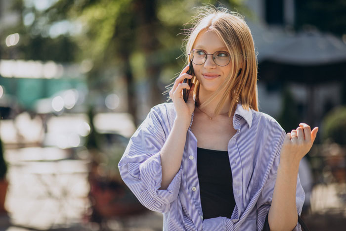 Young woman with glasses talking on phone outdoors, symbolizing a bestie ghosting writer seeking help to break into Hollywood. Young woman with glasses talking on phone outdoors, symbolizing a bestie ghosting writer seeking help to break into Hollywood.