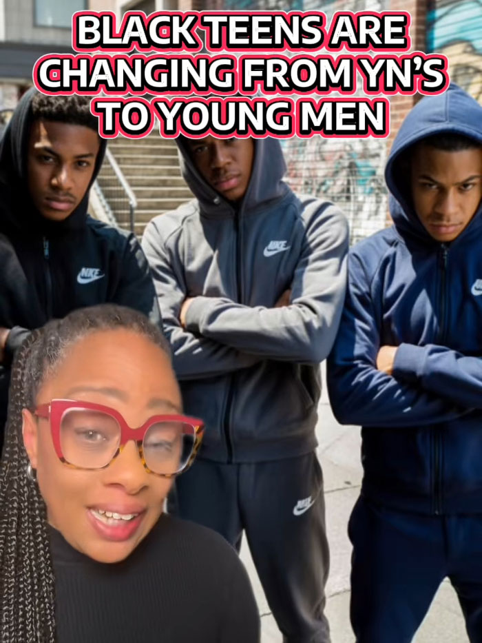 Group of young Black men in hoodies posing outdoors with a woman wearing red glasses, showcasing trend in transforming their looks.