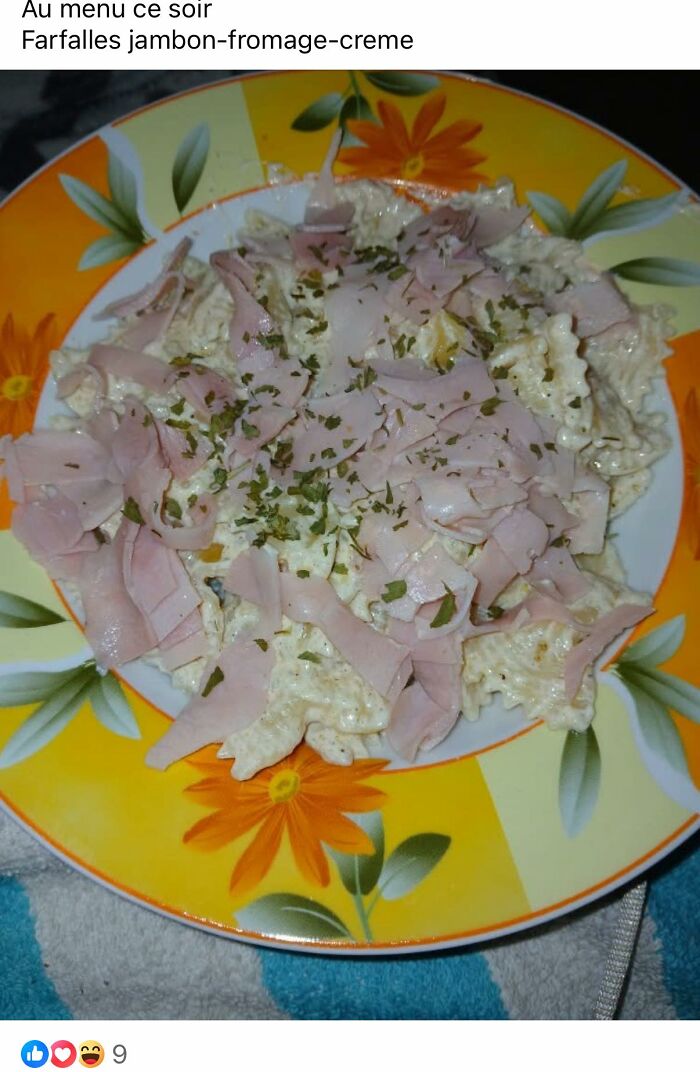 Plate of farfalle pasta with ham and cream sauce topped with herbs, one of the food pics that deserve to be shamed online.