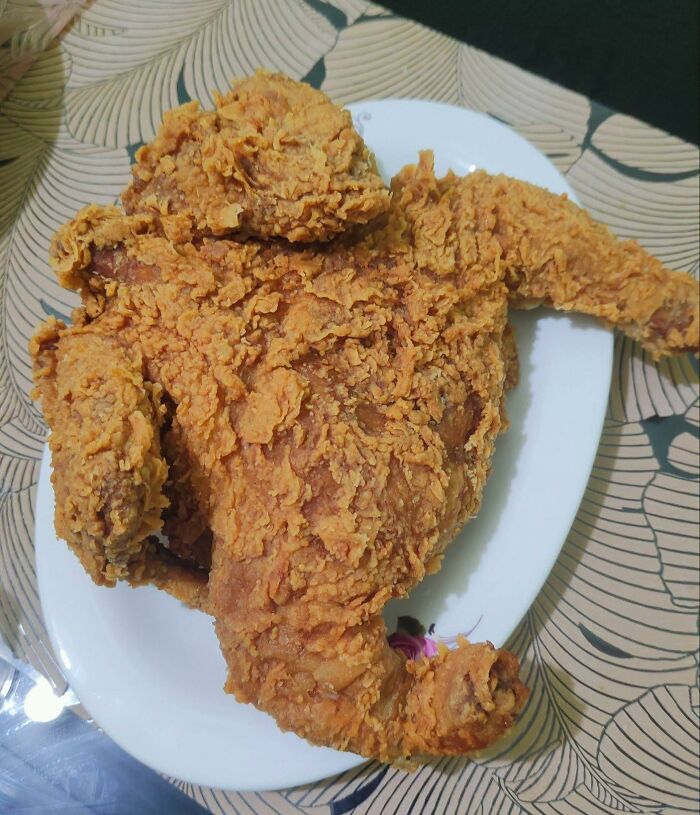 Crispy fried chicken on a white plate close-up, showcasing food pics that deserve to be shamed online.