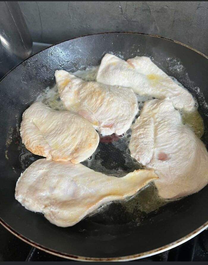 Partially cooked chicken breasts in a pan with uneven cooking and raw spots, a food pic that deserves to be shamed online.