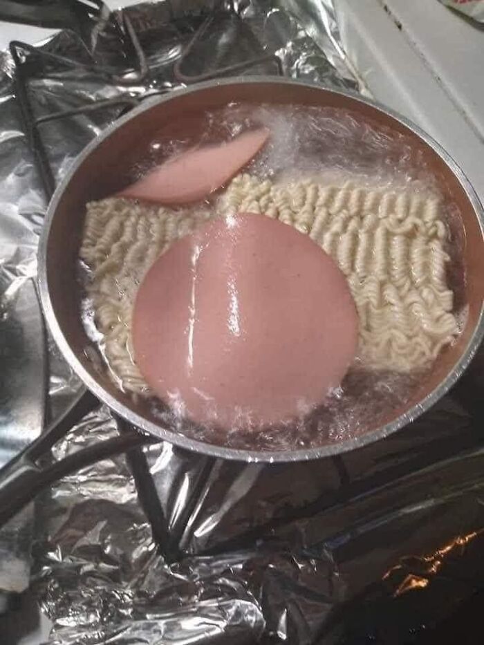 Unusual cooking fail with noodles and a slice of bologna boiling together in a pot, a food pic that deserves shame online.