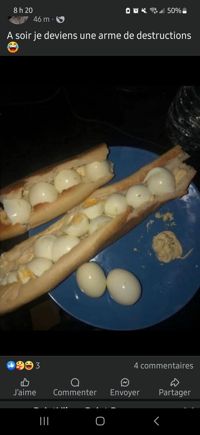 Two baguette sandwiches filled with peeled boiled eggs and a small dollop of mustard on a blue plate, food pics to be shamed.