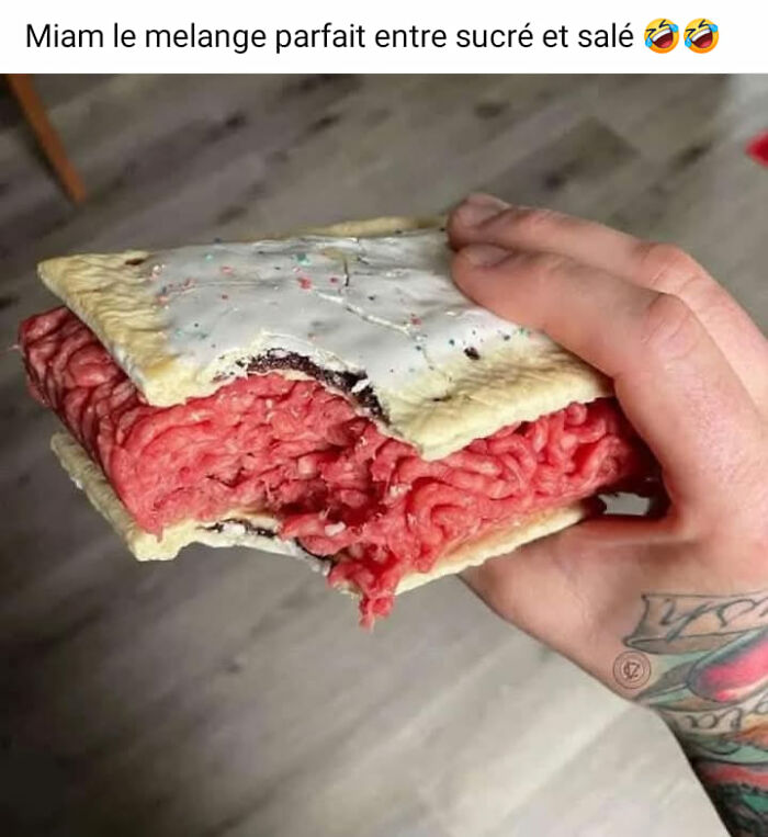 Uncooked ground meat inside a frosted pastry held by a tattooed hand, showcasing a food pic that deserves to be shamed online.