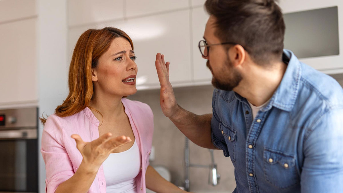 Woman upset and arguing with husband in kitchen after he drinks souvenir wines brought from abroad