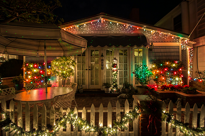 House decorated with festive Christmas lights at night, highlighting HOA restrictions on holiday decor and fines.
