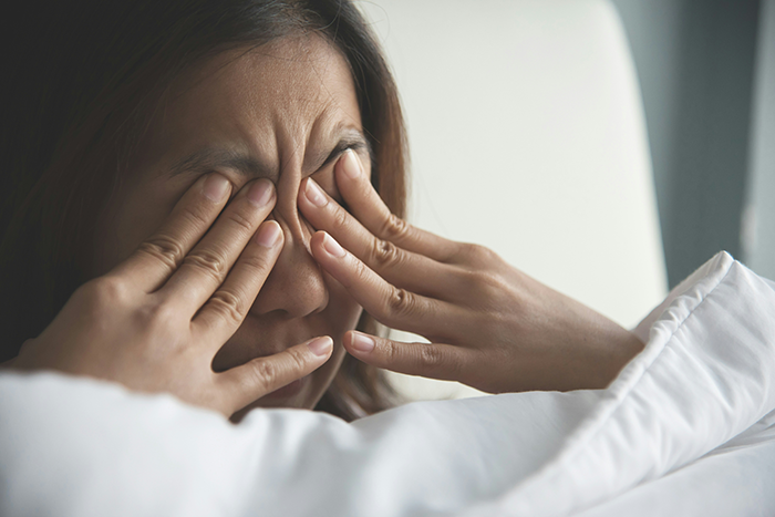 Woman looking horrified and stressed after facing HOA fines for having too festive Christmas decor at home.