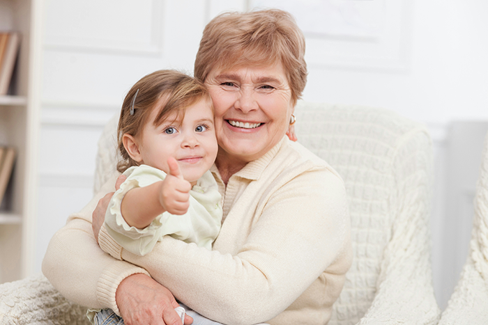 Smiling mama holding toddler giving thumbs up, showing close bond and loving teaching moment at home. Smiling mama holding toddler giving thumbs up, showing close bond and loving teaching moment at home.